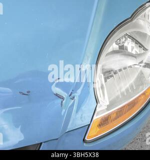 Beschädigte Karosserie. Dellen und Kratzspuren auf der Motorhaube eines Autos. Nahaufnahme Stockfoto