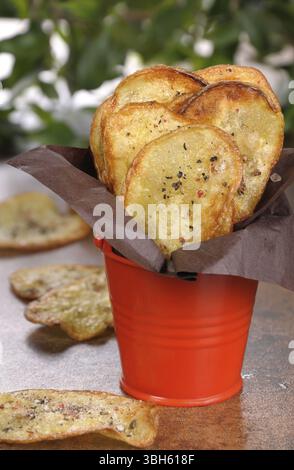 Hausgemachte Kartoffelchips in Papier und gefaltetem Eimer Stockfoto