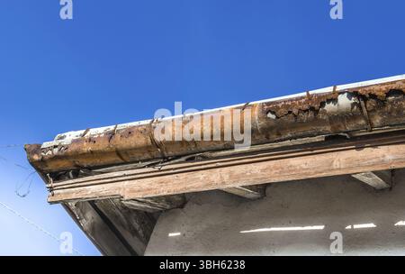 Regenrinnen auf dem alten Haus. Im Hintergrund ist ein blauer Himmel Stockfoto