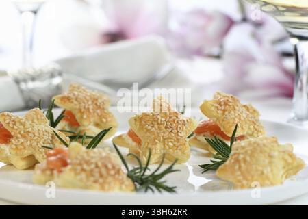Festliche Vorspeise aus Blätterteig in Sternform, gefüllt mit Lachs und Weichkäse. Die perfekte Vorspeise für Ihren Feiertagstisch Stockfoto