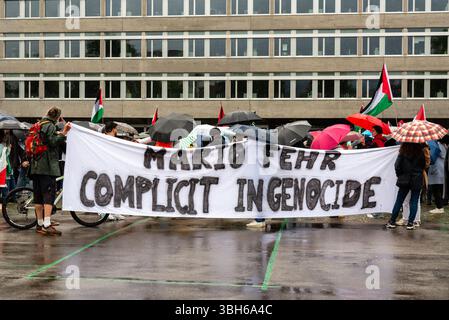 Zürich, Schweiz. Juni 2025. Demonstranten halten ein großes Banner mit der Aufschrift „Mario Fehr Mittäter am Völkermord“ während eines pro-palästinensischen Protestes, der die Haltung des Zürcher Sicherheitschefs zum Gaza-Konflikt kritisiert. Quelle: Fabienne Koch/Alamy Live News. Stockfoto