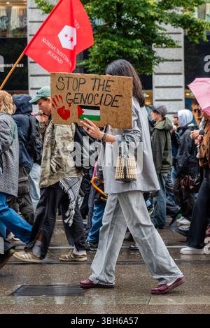 Zürich, Schweiz. Juni 2025. Während einer pro-palästinensischen Demonstration, die ein Ende des Krieges in Gaza fordert, hält ein Demonstrant ein Schild mit der Aufschrift „stoppt den Völkermord“ und kritisiert die Schweizer Beziehungen zu Israel. Quelle: Fabienne Koch/Alamy Live News. Stockfoto