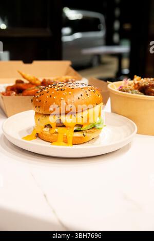 Koreanische, tiefgetrocknete, scharfe rote Hähnchensauce in einer Papierkarton zum Mitnehmen. Stockfoto