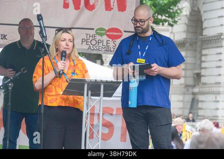 London, Großbritannien. Juni 2025. Die nationale Demonstration der Volksversammlung. Tausende von Menschen marschieren durch das Zentrum Londons und fordern ein Ende der Kürzungen des öffentlichen Dienstes und der Sozialhilfe, während der erste große Anti-austeritätsmarsch unter der britischen Labour-Regierung stattfindet. Die Wahlkampfgruppe People’s Assembly fordert die Regierung auf, „die Reichen und ihren verborgenen Reichtum zu besteuern, um öffentliche Dienstleistungen zu finanzieren“, wobei Gewerkschafter, Gesundheits-, Behinderten-, Wohn- und Sozialaktivisten unter dem Motto „keine Austerität mehr 2,0“ zusammenkommen. Im Bild: Die Arbeiter Holly Turner und Andrew Meyerson sprechen bei der Kundgebung in Whitehall. Stockfoto