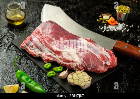 Großes Kalbsstück, Schaftschnitt, frisches Fleisch, schwarzer Hintergrund. Stockfoto