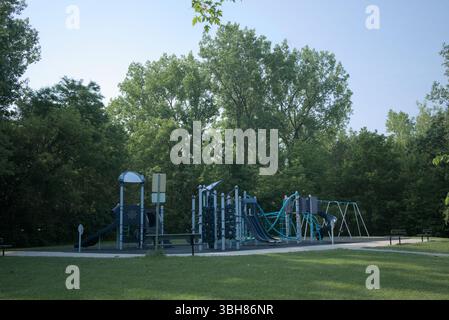 Moderner Outdoor-Spielplatz inmitten grüner Bäume an einem sonnigen Tag Stockfoto