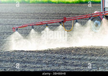 Landwirtschaftliches Bewässerungssystem, das Wasser auf dem Feld mit Wassersprinklern sprüht. Stockfoto