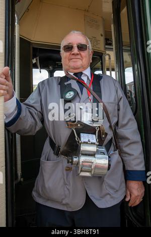 Epsom, Surrey, Großbritannien. Juni 2025. Ein Busführer steht am Eingang eines klassischen Londoner Busses. Freiwillige, die Erbe und klassische Busse betreiben, bieten den Passagieren kostenlose Fahrten an, wobei sie in mehreren Städten auf einer Rundstrecke halten, die in Kingston upon Thames beginnt und in Bookham, Surrey, endet. Die Route 418 ist einer von drei historischen Tagen, an denen Busse, die vom London Bus Museum gespendet wurden, der Öffentlichkeit historische Informationen vermitteln. (Credit Image: © James Willoughby/SOPA Images via ZUMA Press Wire) NUR REDAKTIONELLE VERWENDUNG! Nicht für kommerzielle ZWECKE! Quelle: ZUMA Press, Inc./Alamy Live News Stockfoto