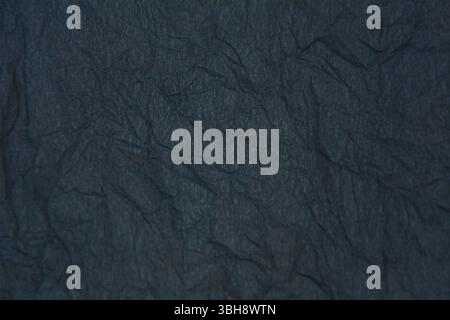 Dunkelgrauer Hintergrund mit starken Falten. Recyceltes dunkelgraues Kraftpapier als Hintergrund. Stockfoto