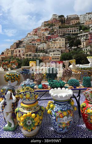 Ausstellung farbenfroher handgefertigter Keramik im Freien in Positano mit Häusern, die hoch über der Stadt errichtet wurden. Mai 25 Amalfiküste, Kampanien Italien Stockfoto