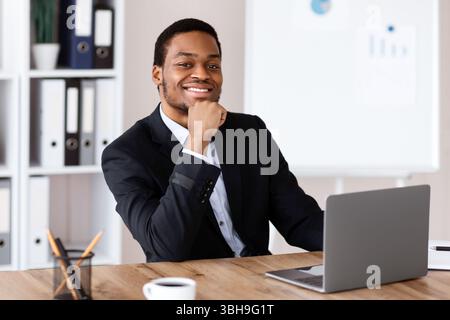 Erfolgreicher afroamerikanischer Geschäftsmann sitzt in seinem Büro Stockfoto