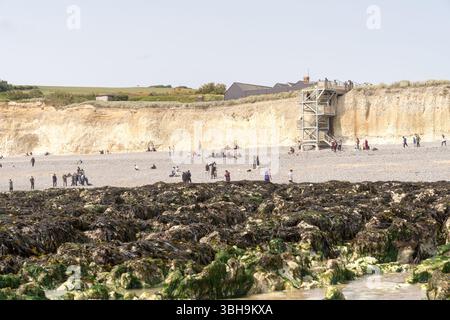 South Downs National Park, Großbritannien – 8. Juni 2025: Besucher am Strand unter erodierenden Kreidefelsen bei Seven Sisters, Küstenerosion und Geologietourismus können sich sonnen, die Wellen und die frische Seeluft genießen und durch die malerischen Wanderwege des South Downs National Park wandern Credit: Xiu Bao/Alamy Live News. Stockfoto