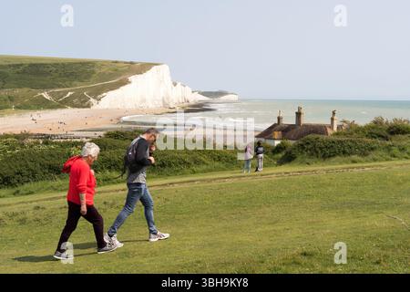 South Downs National Park, Großbritannien – 8. Juni 2025: Spaziergänge im Seven Sisters Country Park mit weißen Kreidefelsen, Freizeitmöglichkeiten an der Küste. Besucher können sich sonnen, die Wellen und die frische Meeresluft genießen und auf den malerischen Wanderwegen des South Downs National Park wandern. Credit: Xiu Bao/Alamy Live News. Stockfoto
