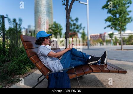 Digitaler Nomad, der in barcelona per Fernzugriff über das Smartphone auf dem Parktisch arbeitet Stockfoto
