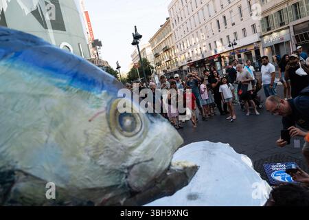 Nizza, England, Frankreich. Juni 2025. Am Welttag der Ozeane veranstalteten Aktivisten der Ocean Rebellion einen theatralischen Protest vor einem Monoprix-Supermarkt in Nizza, Frankreich, um die Bedenken hinsichtlich der industriellen Thunfischfangpraxis zu beleuchten. Die Demonstration zeigte Künstler, die eine riesige Dose Petit Navire Thunfisch mit einem˜toten Seemann enthüllten, begleitet von einer satirischen Darbietung des französischen Liedes˜Il Ã Tait un Petit Navire. Mit dem Protest sollte auf angebliche Menschenrechtsverletzungen und Umweltauswirkungen im Zusammenhang mit der Thunfischfischerei, insbesondere im Zusammenhang mit der Marine Stewardship, hingewiesen werden Stockfoto
