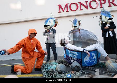 Nizza, England, Frankreich. Juni 2025. Am Welttag der Ozeane veranstalteten Aktivisten der Ocean Rebellion einen theatralischen Protest vor einem Monoprix-Supermarkt in Nizza, Frankreich, um die Bedenken hinsichtlich der industriellen Thunfischfangpraxis zu beleuchten. Die Demonstration zeigte Künstler, die eine riesige Dose Petit Navire Thunfisch mit einem˜toten Seemann enthüllten, begleitet von einer satirischen Darbietung des französischen Liedes˜Il Ã Tait un Petit Navire. Mit dem Protest sollte auf angebliche Menschenrechtsverletzungen und Umweltauswirkungen im Zusammenhang mit der Thunfischfischerei, insbesondere im Zusammenhang mit der Marine Stewardship, hingewiesen werden Stockfoto