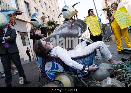 Nizza, England, Frankreich. Juni 2025. Am Welttag der Ozeane veranstalteten Aktivisten der Ocean Rebellion einen theatralischen Protest vor einem Monoprix-Supermarkt in Nizza, Frankreich, um die Bedenken hinsichtlich der industriellen Thunfischfangpraxis zu beleuchten. Die Demonstration zeigte Künstler, die eine riesige Dose Petit Navire Thunfisch mit einem˜toten Seemann enthüllten, begleitet von einer satirischen Darbietung des französischen Liedes˜Il Ã Tait un Petit Navire. Mit dem Protest sollte auf angebliche Menschenrechtsverletzungen und Umweltauswirkungen im Zusammenhang mit der Thunfischfischerei, insbesondere im Zusammenhang mit der Marine Stewardship, hingewiesen werden Stockfoto