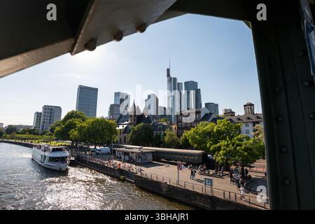Frankfurter Stadtbild des Finanzviertels und des Main von der Eisernen Fußgängerbrücke. Das Tourboot ist eine Attraktion für Touristen. Stockfoto