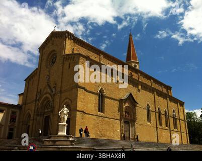 Historische gotische Kirche mit vorderem Innenhof unter einem hellen blauen Himmel. Arezzo, Italien Stockfoto
