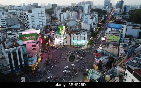 Ho-Chi-Minh-Stadt, Vietnam - 8. Dezember 2022: Luftaufnahme von Motorradfahrern und Autofahrern, die durch den geschäftigen Thanh-Giong-Kreisverkehr fahren. Stockfoto