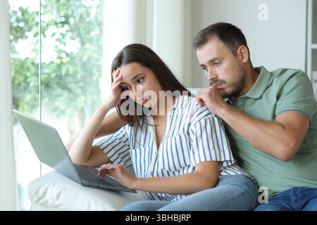 Ein gestresstes Paar beschwert sich, nachdem es sich irrtümlich auf einer Couch zu Hause befand Stockfoto