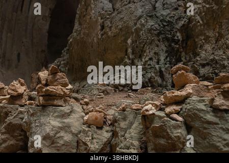 Nahaufnahme der gestapelten felsenhügel in der Höhle, die auf einer zerklüfteten Steinoberfläche ruhen. Stockfoto