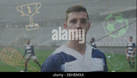 Stehender Fußballspieler in marineblauer gestreifter Uniform auf dem Stadionfeld mit digitalen Sportakkalen. Athleten, Teamwork, Stadion, aktiv, Wettkampf, mod Stockfoto