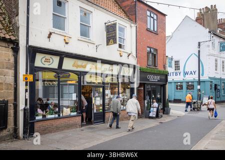 Eine Reihe unabhängiger Geschäfte entlang des Baxtergate in Whitby, einschließlich Botham's Bakery und Teestube. Straßenszene mit einer Reihe traditioneller Geschäfte. Stockfoto