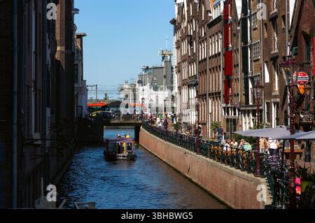 Amsterdamer Kanal mit Booten, engen Gebäuden und Fahrrädern Stockfoto