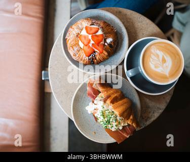 Frisch gebackene Croissants und Gebäck mit Kaffee auf einem Tisch in einem Café Stockfoto