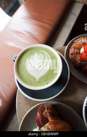 Tasse grüner Matcha heißes Getränk auf einem Kaffeetisch Stockfoto