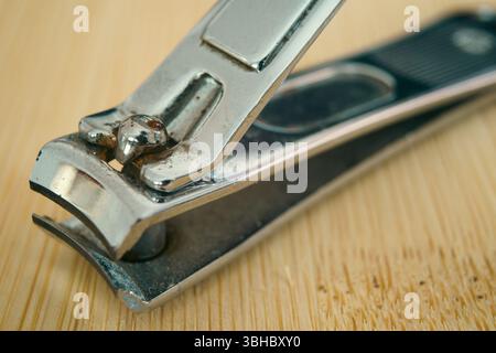 Nagelschneider auf Holzoberfläche, Makrozusammensetzung. Stockfoto