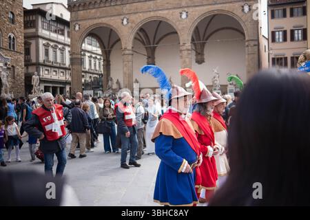 Florenz, Italien, 04.16.2025: Ritterprozession durch das Zentrum einer italienischen Stadt. Eine Prozession in historischen Kostümen mit Fahnen geht durch Stockfoto