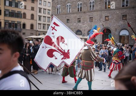Florenz, Italien, 04.16.2025: Ritterprozession durch das Zentrum einer italienischen Stadt. Eine Prozession in historischen Kostümen mit Fahnen geht durch Stockfoto