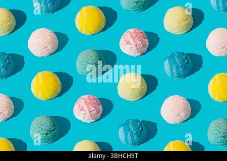 Buntes Eis-Muster auf hellblauem pastellfarbenen Hintergrund. Sommer-Food-Konzept. Minimales isometrisches Layout. Eisschaufel-Ästhetische Idee. Stockfoto