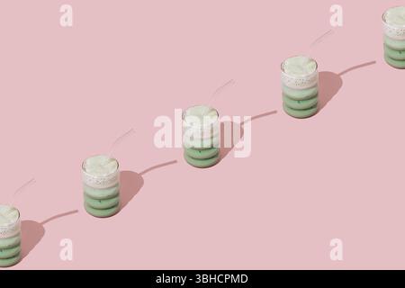 Kreatives Sommermuster aus gefrorenem Matcha-Latte auf pastellrosa Hintergrund. Minimales gesundes Matcha Latte Konzept. Trendige Drink-Idee. Kopierbereich. Stockfoto