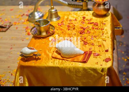 Gegenstände der Aarti-Zeremonie, die Pujaris auf Ganges verwendet hat, auf goldenem Tisch mit Blütenblättern. Varanasi, Indien. Stockfoto