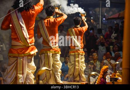 Pujaris oder indische Priester führen eine Aarti-Zeremonie am Ufer des Ganges vor der Menschenmenge, Varanasi, durch. Indien. Stockfoto