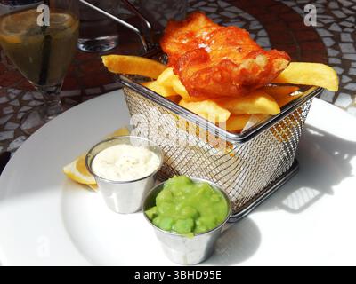 Traditioneller britischer Fisch und Chips, serviert mit matschigen Erbsen und Tatarensauce. Kinsale, Irland Stockfoto