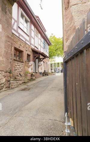 Enge Gasse mit traditionellen Fachwerkhäusern und Steinmauern in einem historischen Viertel, Familienfest in Neubulach, Bezirk Calw, Deutsch Stockfoto