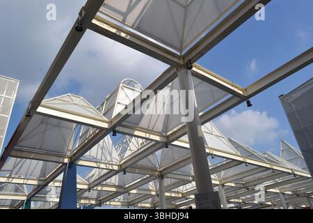 Gestaltung der zukünftigen Gesellschaft. Ungewöhnliche Dachinstallation als Stadtmarktbau. Metallbalken im Winkelschnitt. Dachabschnitte mit Dreieckrahmen. Stockfoto