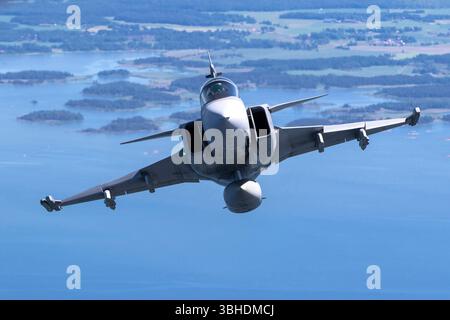 Eine schwedische Luftwaffe Saab JAS-39C Gripen, Teil der Luftverteidigungsflotte des Landes, fliegt während einer Luft-Luft-Fotomission. Der JAS-39C Gripen kann von kurzen Landebahnen aus betrieben werden und ist mit fortschrittlichen Avionik- und Waffensystemen ausgestattet. Stockfoto