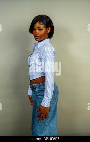 Studio-Porträt einer stilvollen jungen schwarzen Frau mit gestreiftem Hemd und Jeans Stockfoto