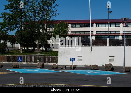 Zwei blaue, barrierefreie Parkplätze in einem sonnigen, modernen Stadtgebiet von Mosfellsbær Stockfoto