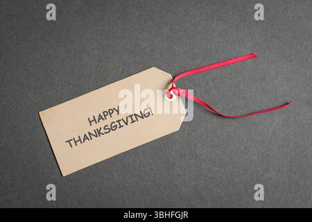 Happy Thanksgiving-Notiz auf einem Schild mit rotem Band. Draufsicht. Stockfoto