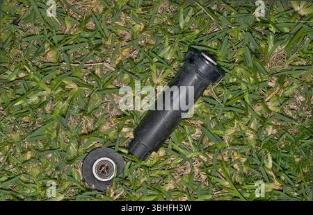 Defekte Sprinklerkopfdüse auf dem Rasen von einem Unfall im Garten im Garten des Rasenmähers. Stockfoto