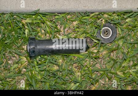 Defekte Sprinklerkopfdüse auf dem Rasen von einem Unfall im Garten im Garten des Rasenmähers. Stockfoto