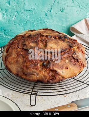 Dinkel Rosinenbrot mit Butter an der Seite – eine rustikale Frühstücks- oder Nachmittagsszene, serviert auf einem weißen Teller, Schneidebrett oder Kühlregal. Stockfoto