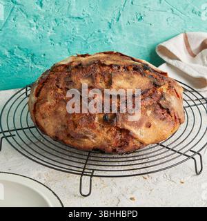 Dinkel Rosinenbrot mit Butter an der Seite – eine rustikale Frühstücks- oder Nachmittagsszene, serviert auf einem weißen Teller, Schneidebrett oder Kühlregal. Stockfoto