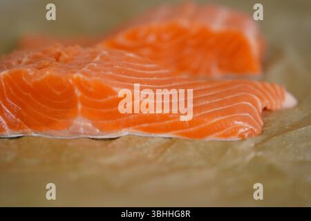 Frisches rohes Lachsfilet auf Pergamentpapier Stockfoto